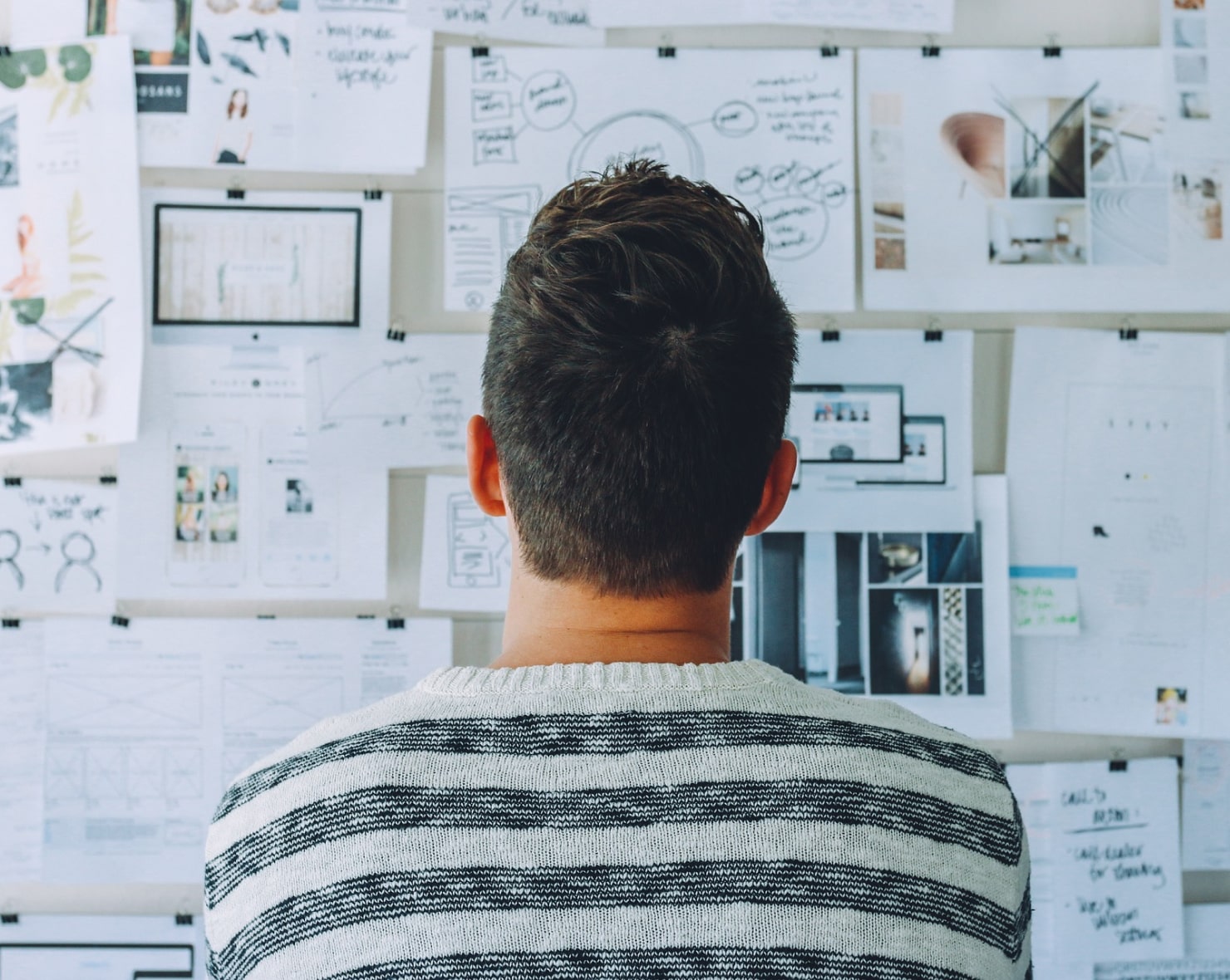 UI designer working on designing screens and wireframes on the whiteboard.